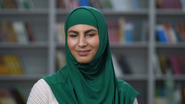 Pretty arab woman in hijab smiling at the camera - 映像、動画