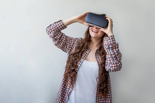 Sorria jovem usando óculos realidade virtual VR capacete headset no fundo branco. Smartphone usando com óculos de realidade virtual. Tecnologia, simulação, oi-tech, conceito de videogame - Foto, Imagem