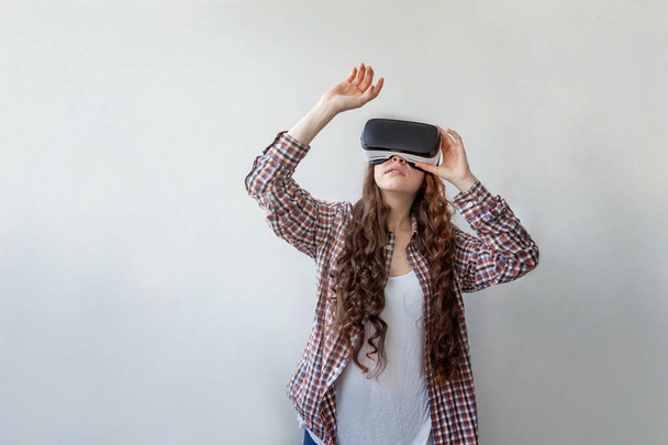 Uśmiechnij się młoda kobieta nosząca okulary VR wirtualnej rzeczywistości na białym tle. Smartfon wykorzystujący gogle wirtualnej rzeczywistości. Technologia, symulacja, hi-tech, koncepcja gry wideo - Zdjęcie, obraz