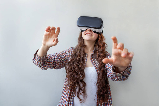 Улыбнитесь молодой женщине в шлеме виртуальной реальности VR очки на белом фоне. Смартфон с очками виртуальной реальности. Технологии, технологии, хай-тек, концепция видеоигр - Фото, изображение