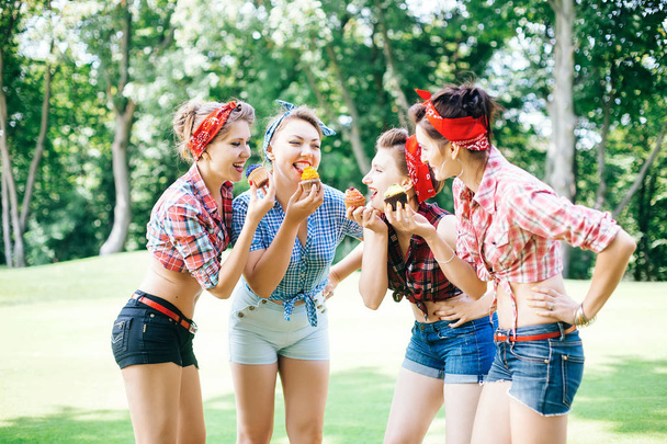 Група друзів у парку проводить веселу вечірку. Веселі дівчата з тортами в руках. партії Хен
 - Фото, зображення
