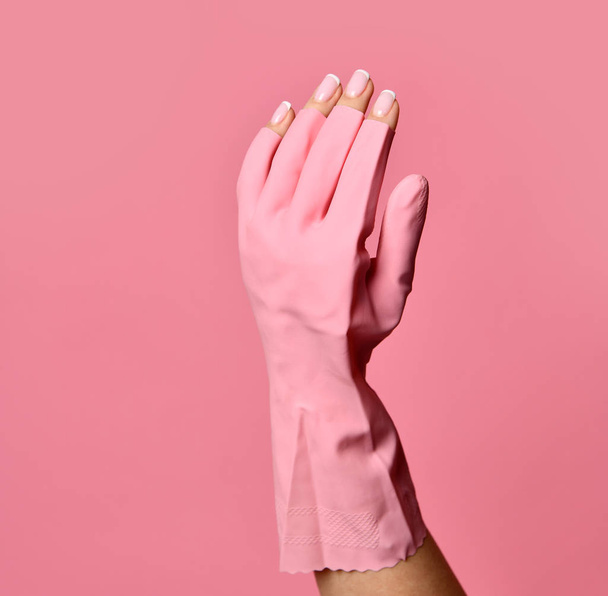 Woman hand in glove cares about hands nails. Manicure beauty salon. Nails filing with file on pink - Photo, Image