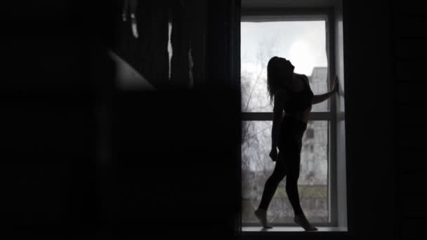 Young girl gymnast on black background - Felvétel, videó