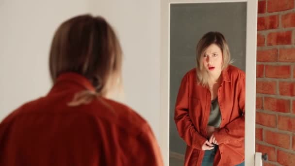 Mujer yound feliz vestirse cerca del espejo
 - Imágenes, Vídeo
