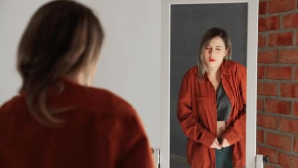 Happy yound woman dressing up near mirror - Footage, Video