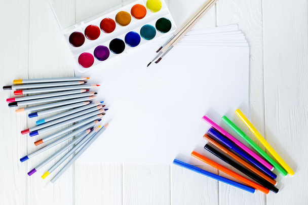 Material escolar para desenhar sobre a mesa: papel, lápis, tintas, marcadores
 - Foto, Imagem