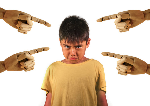 group of wood hands pointing finger to young sad and stressed schoolboy victim of abuse and bullying isolated on white background in kid harassed and bullied at school concept - Foto, imagen