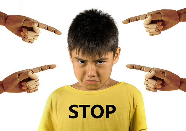 group of wood hands pointing finger to young sad and stressed schoolboy crying victim of abuse and bullying isolated on white background in kid harassed and bullied at school concept - Фото, изображение