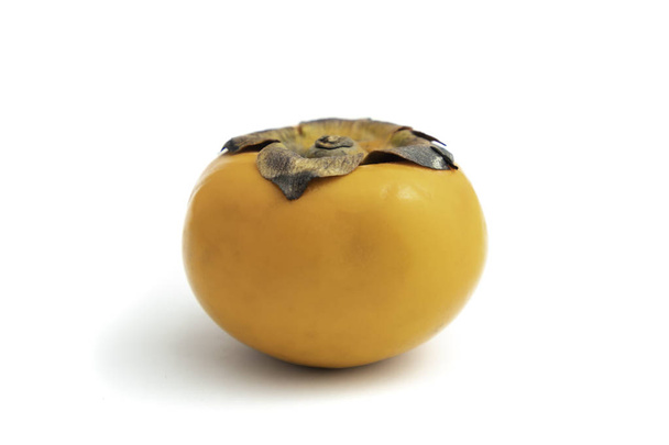 Datolyaszilva egy sárga gyümölcsöt. a tudományos neve a Diospyros kaki van. elszigetelt fehér háttér, és a Vágógörbe. - Fotó, kép