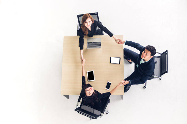 Top view of successful of group business people holding their hands together on wooden desk at office.Friendship teamwork concept - 写真・画像