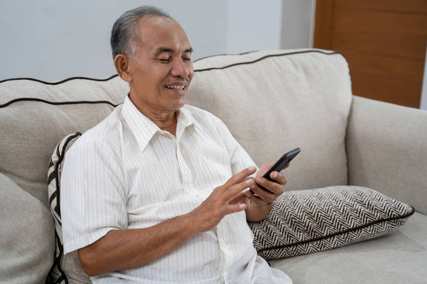 old man using smartphone at home - Photo, image