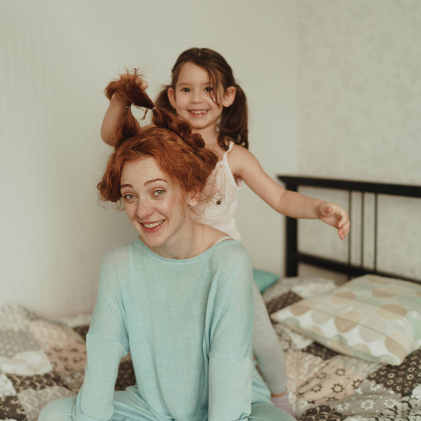 cozy photo session of beautiful happy mother and daughter, indoor - Fotó, kép