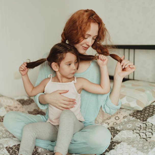 cozy photo session of beautiful happy mother and daughter, indoor - Foto, afbeelding