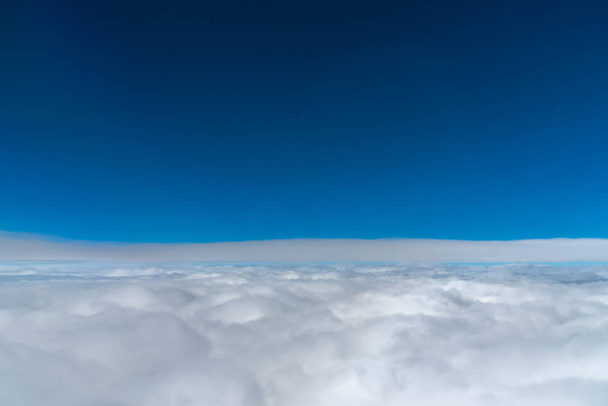dunkelblauer Himmelshorizont, oben in der Luft. Blick aus dem Flugzeugfenster. - Foto, Bild