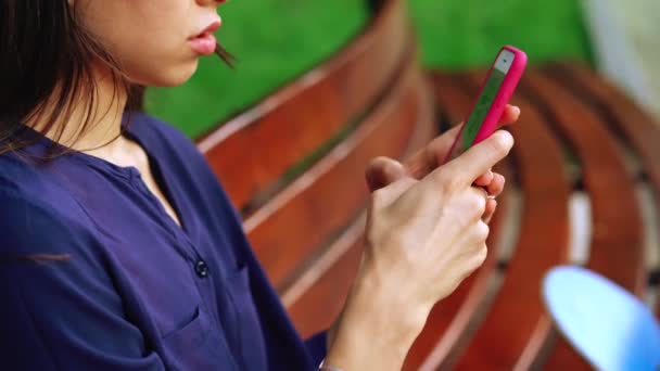Woman sits on the bench and using smartphone. Close view - Footage, Video