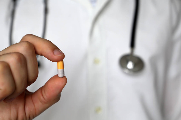 Arzt mit Pille, Mann mit Stethoskop-Kapsel. Konzept von Medikamenten, Vitaminen, Rezepten, ärztlicher Untersuchung, Apotheker - Foto, Bild