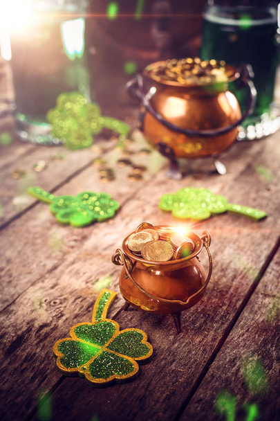 St. Patricks Day concept, green shamrocks and a full cauldron of gold coin - Photo, image