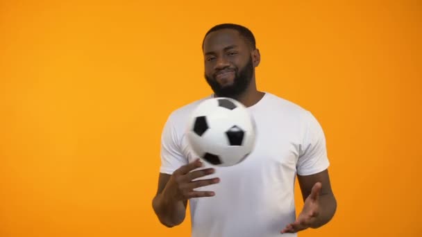 African-American man playing with soccer ball and showing thumbs down, losing - Video, Çekim