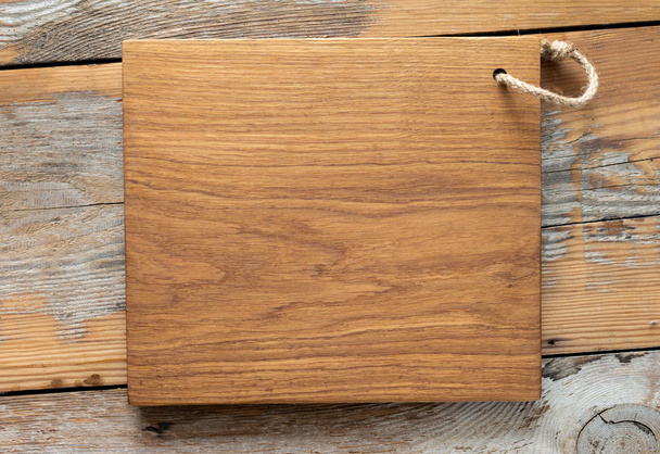 Oak cutting board handmade on wooden kitchen table top view - Foto, afbeelding