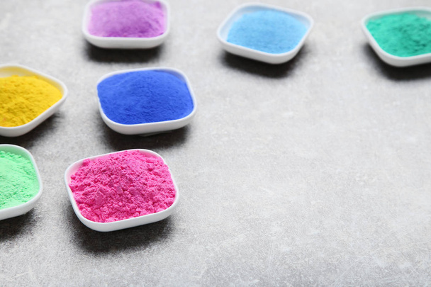 Colorful holi powder in bowls on grey background - Fotó, kép