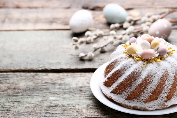 Easter cake with eggs and tree branches on grey wooden table - Zdjęcie, obraz