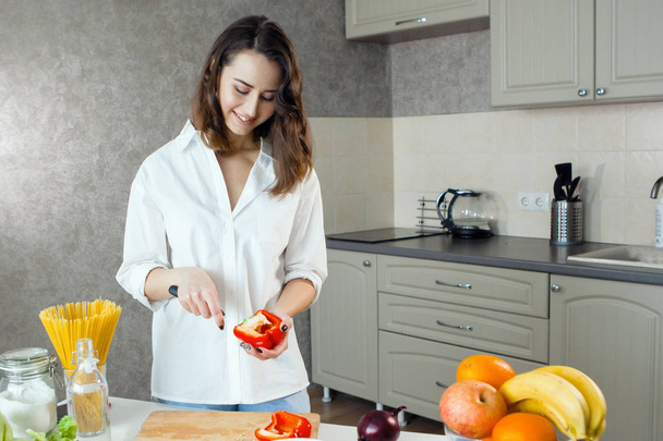 жінка ріже червоний перець на домашній кухні, вибірковий фокус
 - Фото, зображення