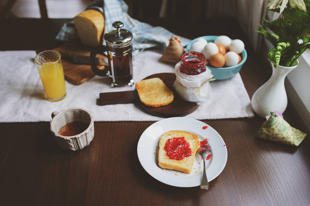 country cottage kitchen with breakfast on wooden table. Toast with jam, farm eggs and coffee - Valokuva, kuva