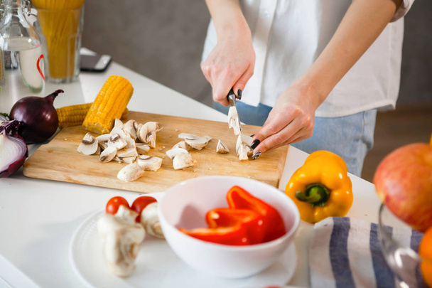 mujer cortando setas en la cocina doméstica, enfoque selectivo
 - Foto, imagen