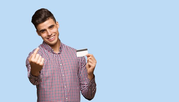 Młody człowiek posiadający karty kredytowej, zapraszając do kontaktu - Zdjęcie, obraz