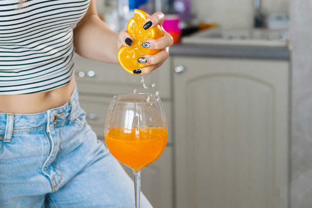 woman making orange fresh, focus on foreground - Foto, afbeelding