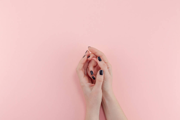 Stijlvol trendy vrouwelijke zwarte manicure. Mooie jonge vrouw handen op duizendjarige roze pastel achtergrond. Beauty en Spa concept. Sjabloon voor vrouwelijke blog social media - Foto, afbeelding