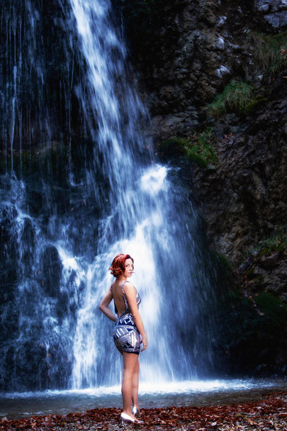 滝の前に、銀のミニのドレスの赤毛の女性の肖像画 - 写真・画像