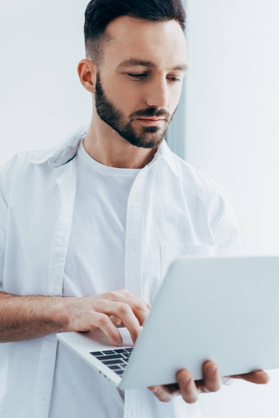 Handsome young man with beard holding laptop - 写真・画像