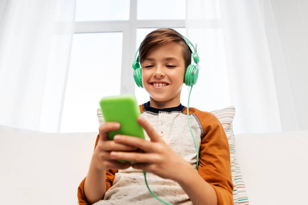 happy boy with smartphone and headphones at home - Zdjęcie, obraz
