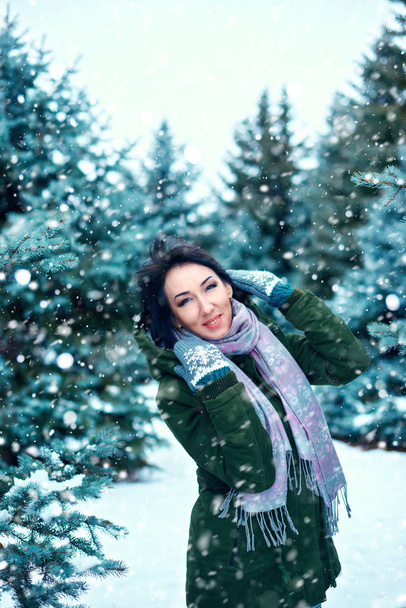 mooie vrouw is in de winter bos, groene sparren met sneeuw - Foto, afbeelding