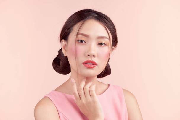 Belle fille asiatique avec maquillage professionnel et coiffure élégante isolée sur rose. Cosmétiques et maquillage
 - Photo, image