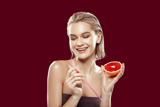 Young photo model feeling cheerful posing with grapefruit - Фото, изображение