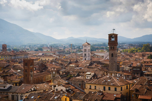 Vista de Torre Delle Ore desde lo alto de la Torre Guinigi, Lucca, Toscana, Italia. Vista panorámica de la ciudad pintoresca postal de viaje
. - Foto, imagen