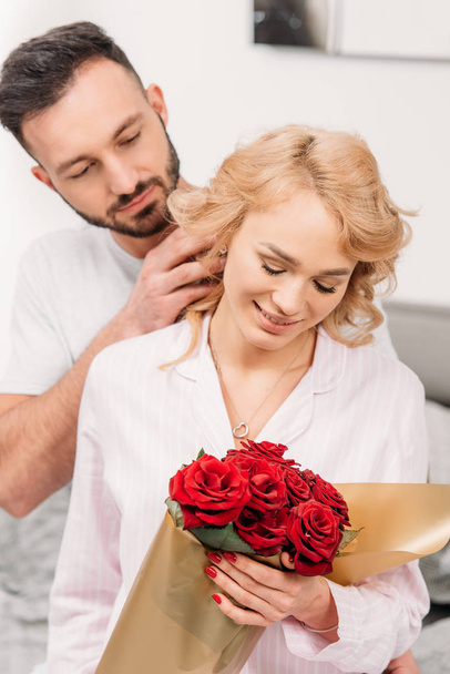 Happy romantic couple posing with red roses - Φωτογραφία, εικόνα