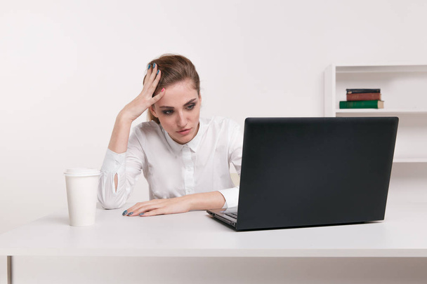 Young attractive woman at modern office desk, working on laptop, massaging temples to forget about constant headaches, noisy loud office giving a migraine, relieving stress, chronic pain, help soothe - Photo, Image