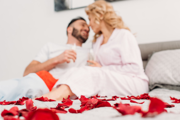 Laughing couple lying in bed with champagne glasses in valentine's day - Foto, Imagem