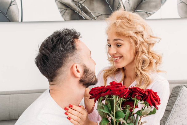 Blonde young woman looking at boyfriend with smile - Photo, image