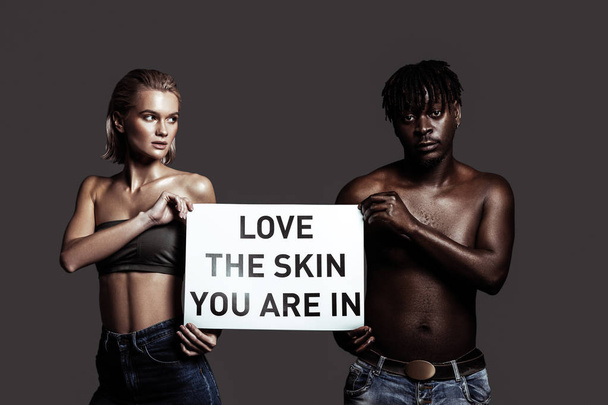 Love your skin. Models having different colors of skin supporting diversity asking people to love their skin - Zdjęcie, obraz