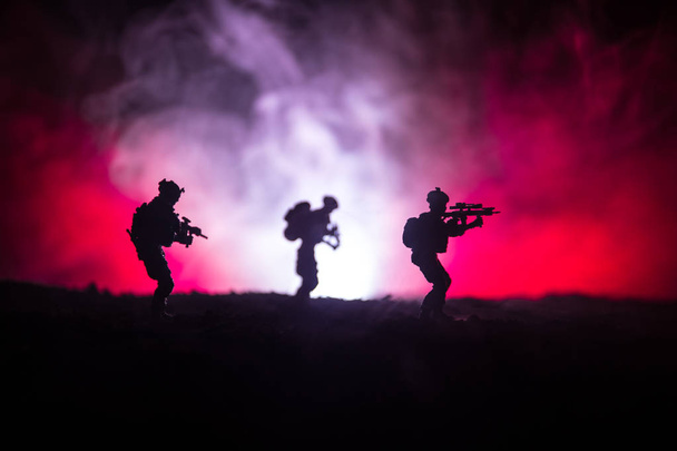 Katonai katona silhouette fegyvert. Háború fogalmát. Katonai sziluettek harci jelenet, a háború köd ég háttér, háború katona Silhouette felhős Skyline éjszaka alatt. Támadás jelenet - Fotó, kép