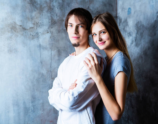 happy beautiful young couple against studio background - Фото, изображение