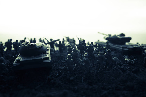 Concepto de guerra. Siluetas militares que luchan escena en el fondo del cielo niebla de guerra, Soldados de la Guerra Mundial Siluetas debajo del horizonte nublado al atardecer. Escena de ataque. Vehículos blindados. tanque en acción
 - Foto, imagen