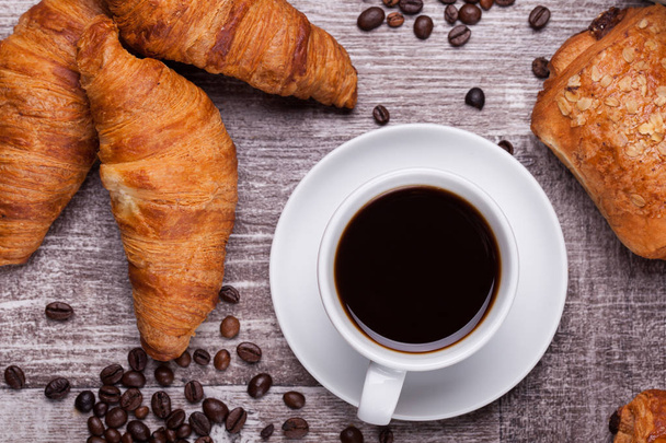Tasse de café chaud et croissants fraîchement cuits sur table en bois sombre
 - Photo, image