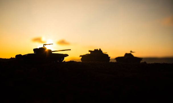 Concept van de oorlog. Militaire silhouettes vechten scène op oorlog mist hemelachtergrond, Wereldoorlog soldaten silhouetten onder bewolkte Skyline bij zonsondergang. Aanval scène. Gepantserde voertuigen. tank in actie - Foto, afbeelding