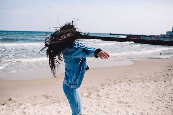 Closeup of neck of a girl looking something in the distance with wind in her hair. Woman body part on the beach - focus on the hair. Anonymous, no visible face.Dancing and relaxing, having fun.emotional,joy,happiness - Photo, Image