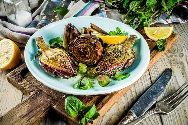 Cooked baked artichoke, alla romana, grilled artichoke flowers with olive oil, lemon, garlic, mint  and spices. Copy space - Photo, Image